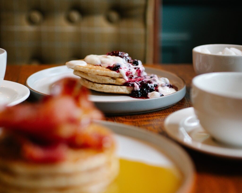 pancakes with fruit compot and greek yogurt served at breakfast during a stay at the snooty fox